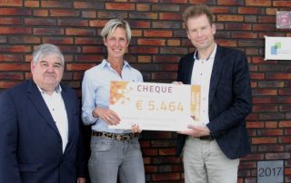 Mensen voor gebouw met cheque